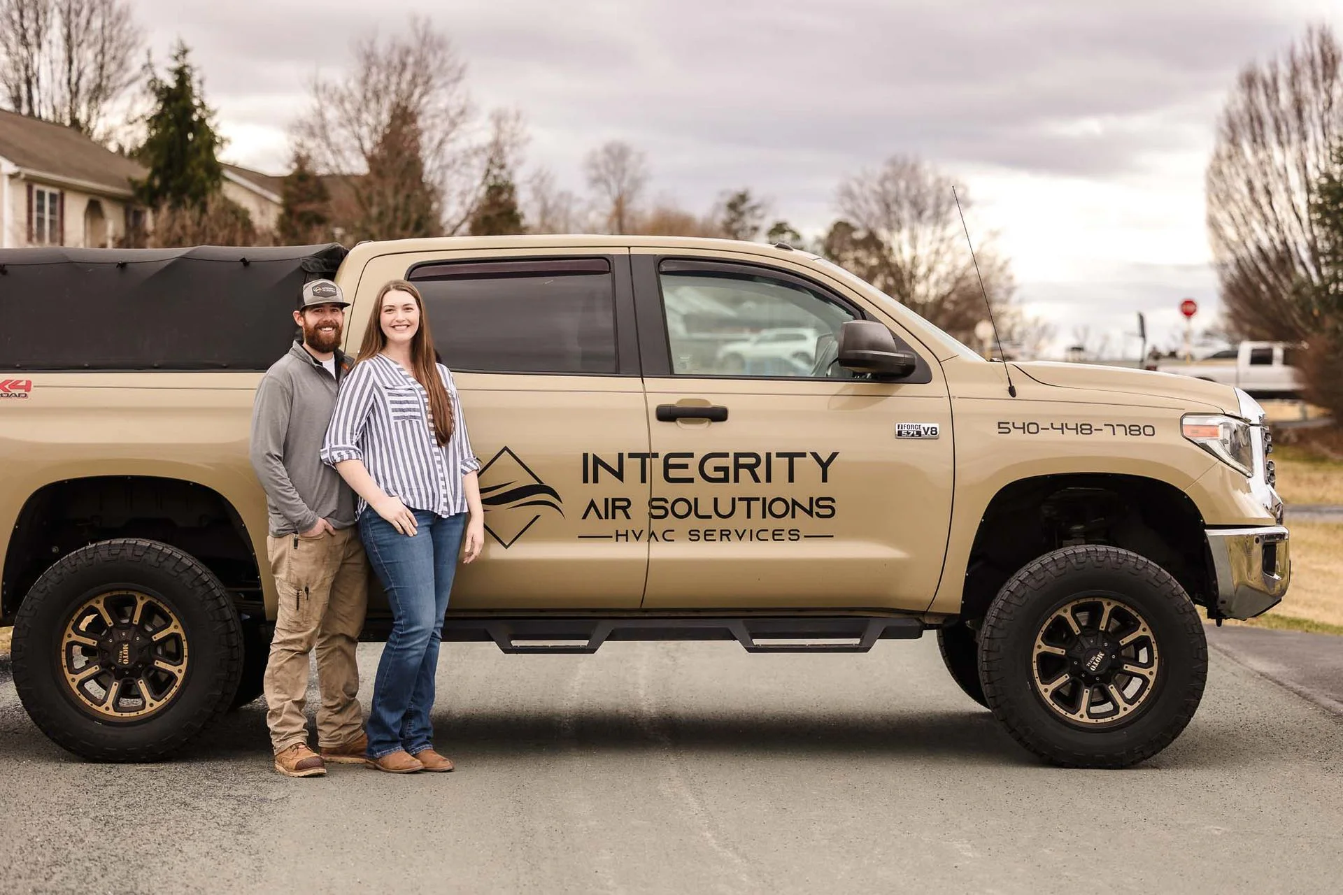 Lucas and Taylor of Integrity Air Solutions beside their service truck